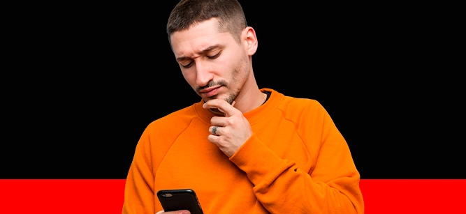 Imagem mostra homem pensativo utilizando um smartphone